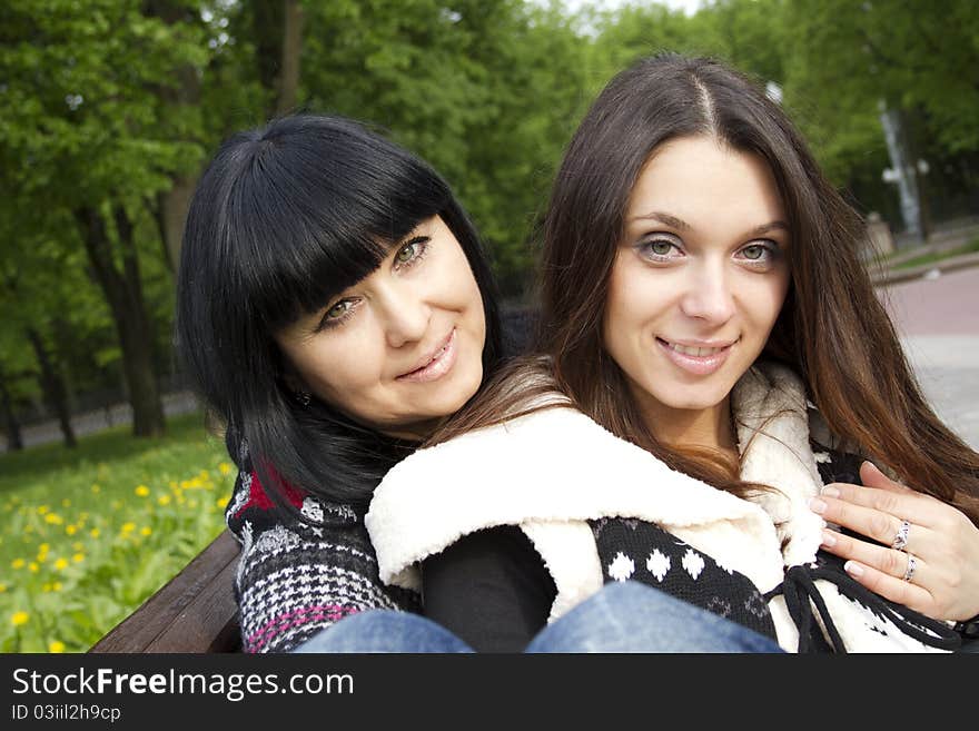 Portrait of smiling mother and teenage daughter hugging in the park happy. Portrait of smiling mother and teenage daughter hugging in the park happy