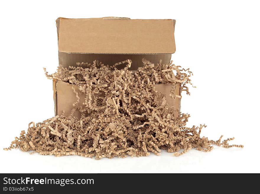 Cardboard shipping box with recycled brown paper protective filler, isolated over white background. Cardboard shipping box with recycled brown paper protective filler, isolated over white background.