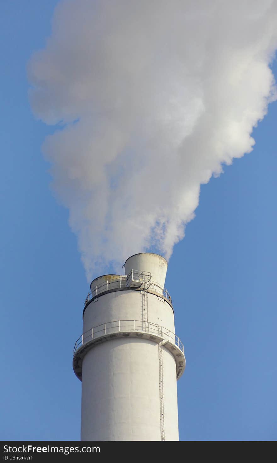 Close-up view of smoking smokestack against blue sky. Close-up view of smoking smokestack against blue sky