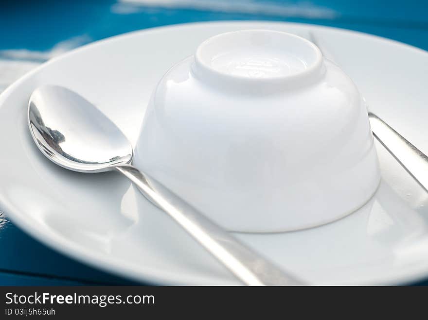 Close up on fork and plate in blue background. Close up on fork and plate in blue background.