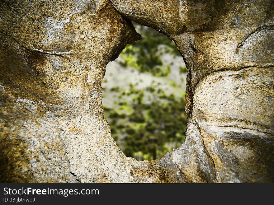 A rock high in the Clear Creek mountain range where wind has for years funnelled thru a draw to bore a hole thru a rock. A rock high in the Clear Creek mountain range where wind has for years funnelled thru a draw to bore a hole thru a rock.