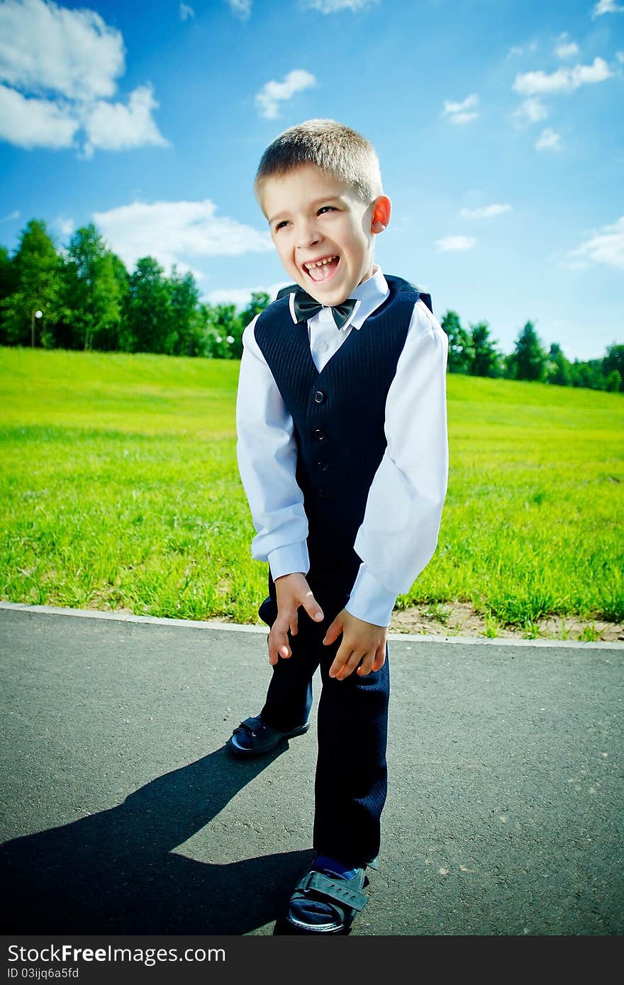 Little boy in a shirt and vest in park