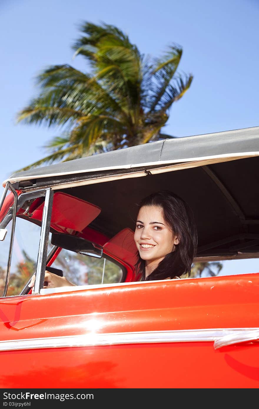 Beautiful young woman driving old car and smiling. Beautiful young woman driving old car and smiling