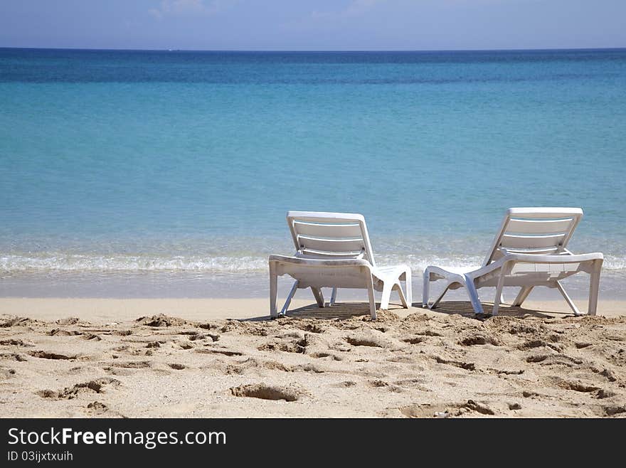 Two sunbeds on a tropical beach near the sea. Two sunbeds on a tropical beach near the sea