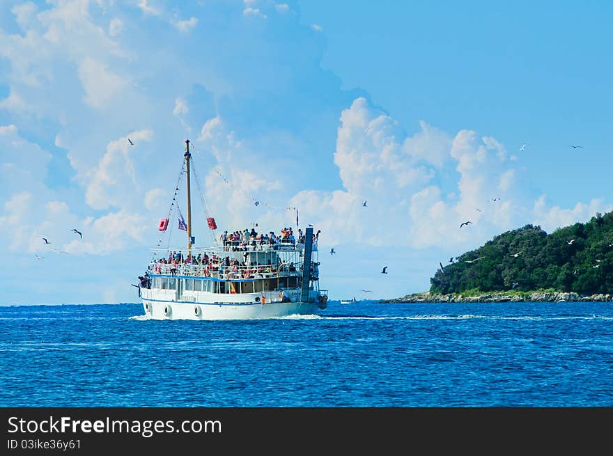 Tourists floating on white boat on the sea of Adriatic