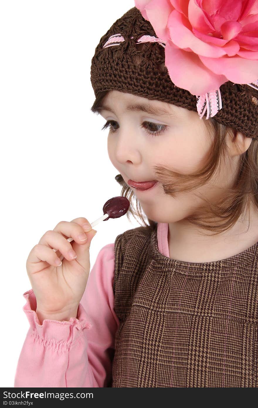 Cute brunette toddler earing a lollipop against white background. Cute brunette toddler earing a lollipop against white background