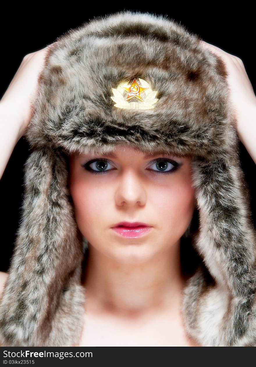 Image showing pretty young blonde female isolated against black with fur hat. Image showing pretty young blonde female isolated against black with fur hat