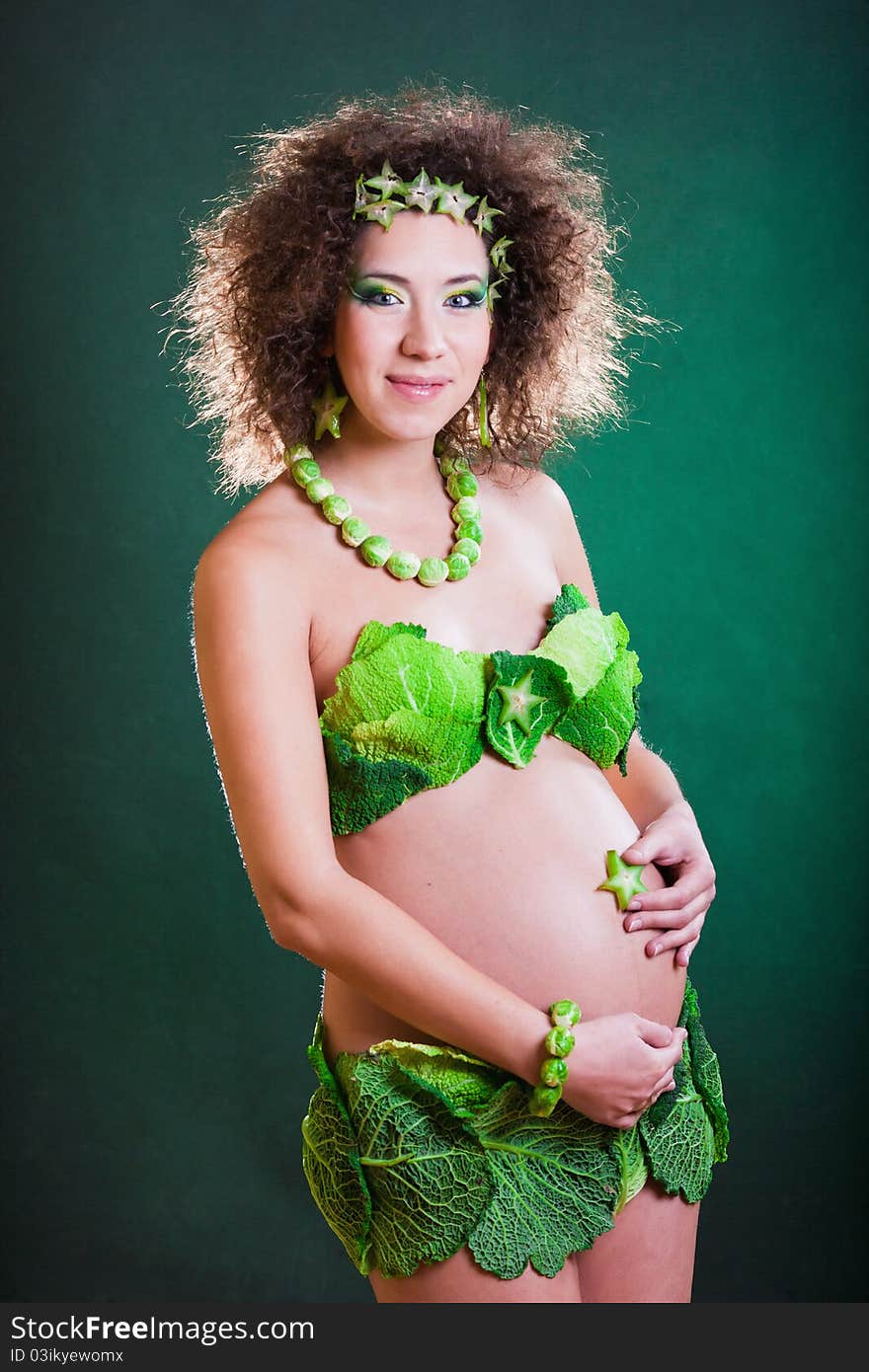 Beautiful pregnant young woman dressed in cabbage