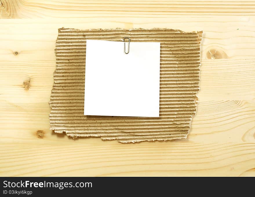 White blank on ripped cardboard on wooden background