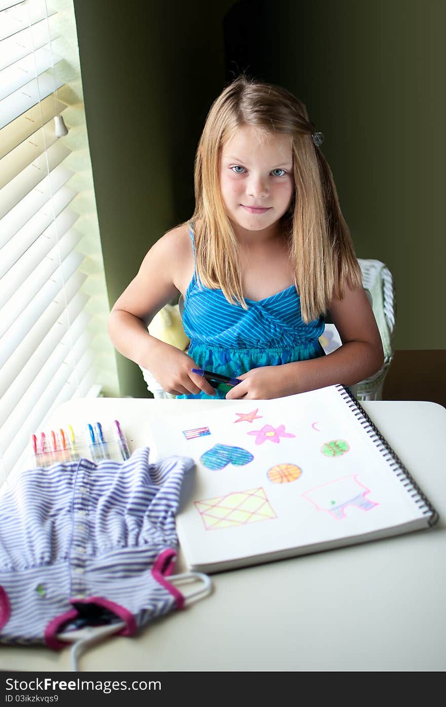 Young girl drawing by window