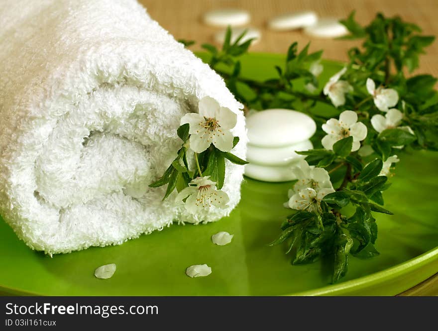 Spa composition of towel, stones and spring branch with flowers. Spa composition of towel, stones and spring branch with flowers