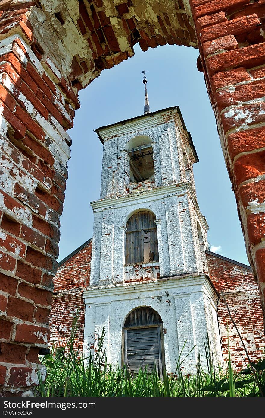 The bell tower of the Orthodox Church. Brick arch church gates.