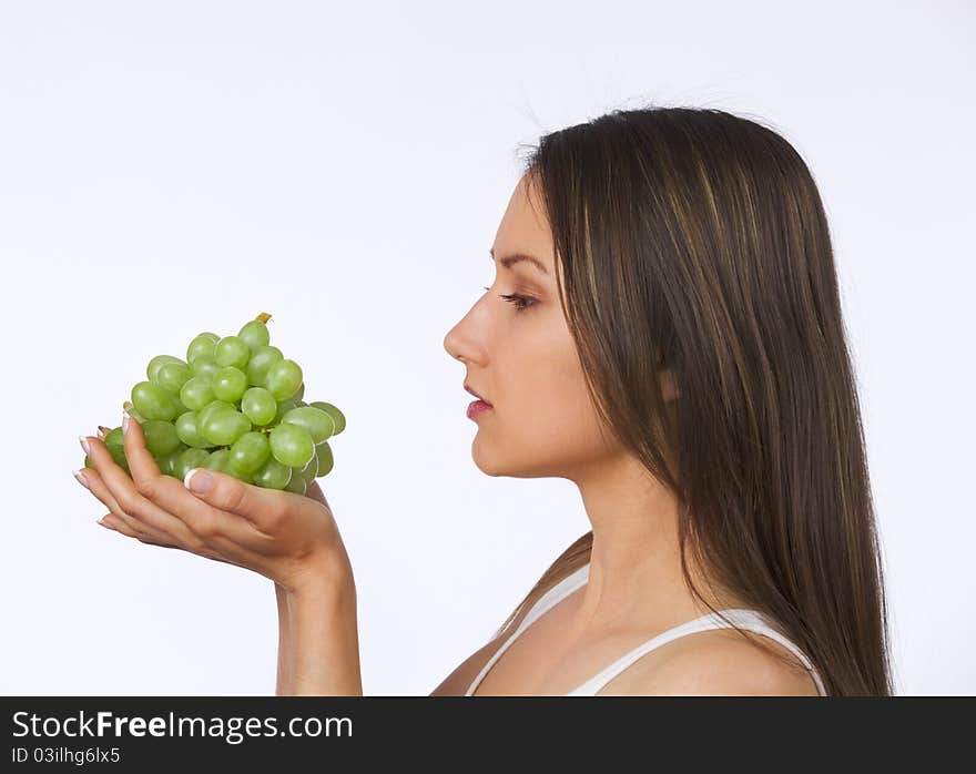 Young woman looking at fresh grapes in her hands. Young woman looking at fresh grapes in her hands