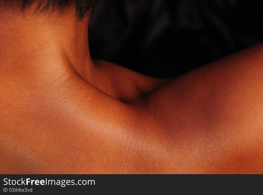 An over the shoulder, abstract shot of a black / African-American woman's neck and shoulder with brilliant copper & mahogany tones. An over the shoulder, abstract shot of a black / African-American woman's neck and shoulder with brilliant copper & mahogany tones.