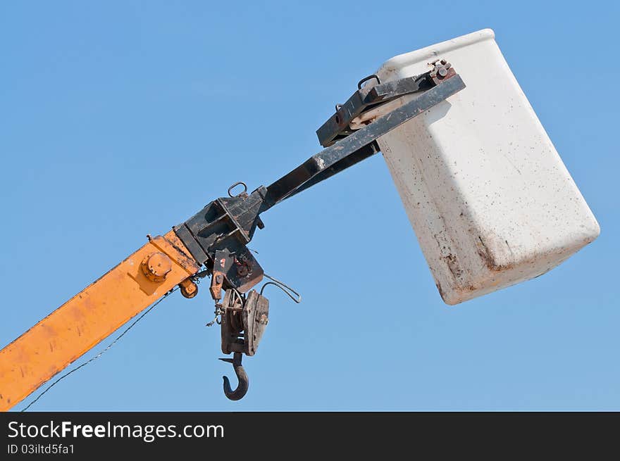 Top part of a heavy crane against a blue sky.