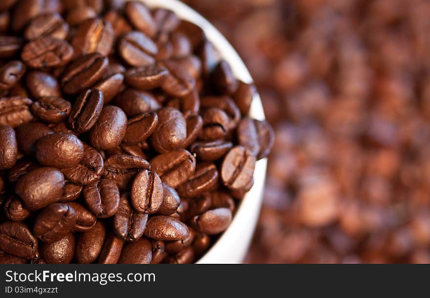 A close-up image of coffee beans in a coffee cup and its surroundings.