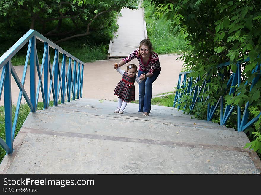 Mother and her little daughter on park staircase. Mother and her little daughter on park staircase.