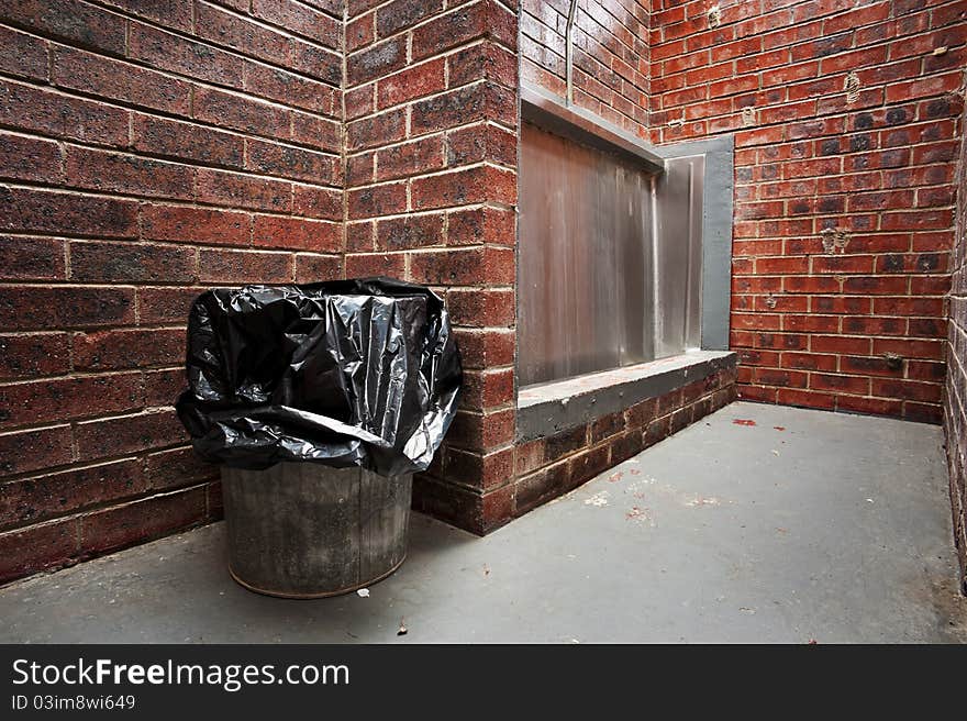 The urinal and a trash can in a mens public restroom. The urinal and a trash can in a mens public restroom.