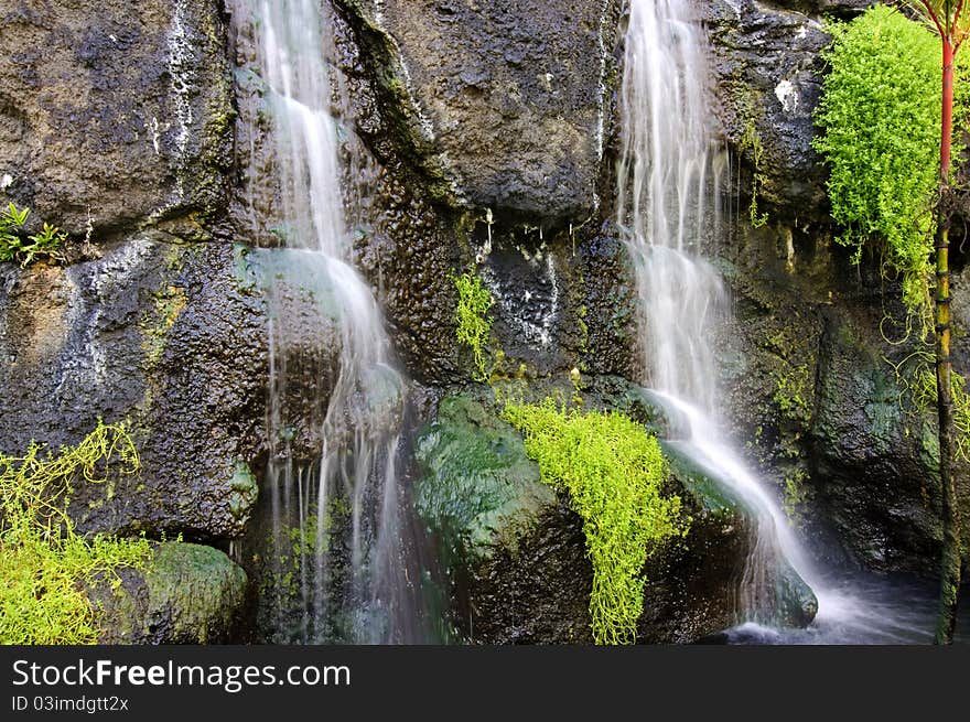 Water falling over lava rocks and into a pond in Hawaii. Water falling over lava rocks and into a pond in Hawaii.