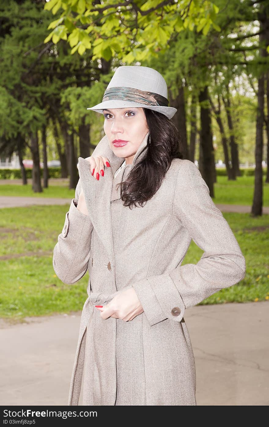 Thoughtful beautiful brunette strolls in the park