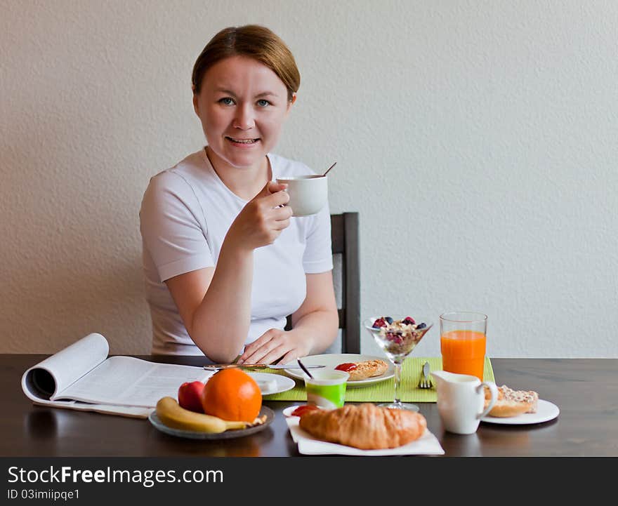 Woman drinking coffe while having her breakfast. Woman drinking coffe while having her breakfast