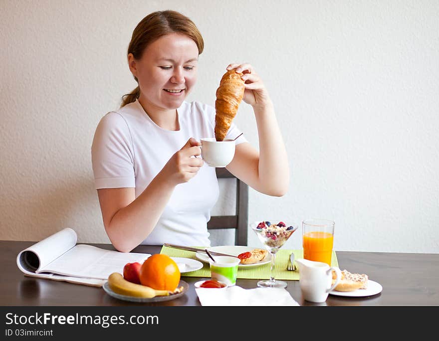 Woman Dunking Croissant In Coffee