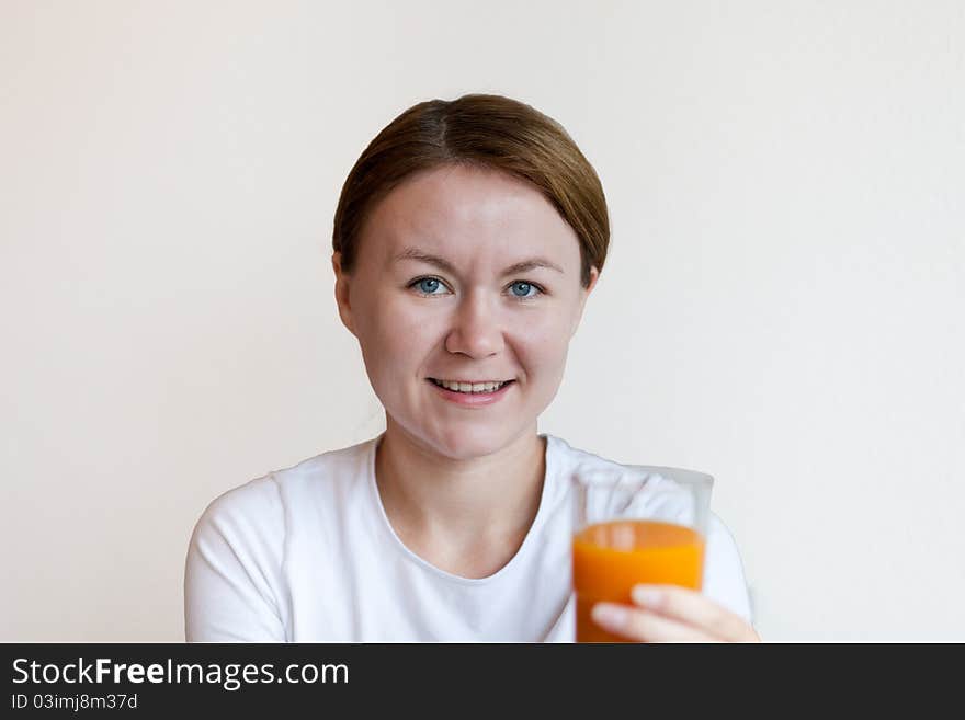 Woman holding a glass of orange juice and smiling