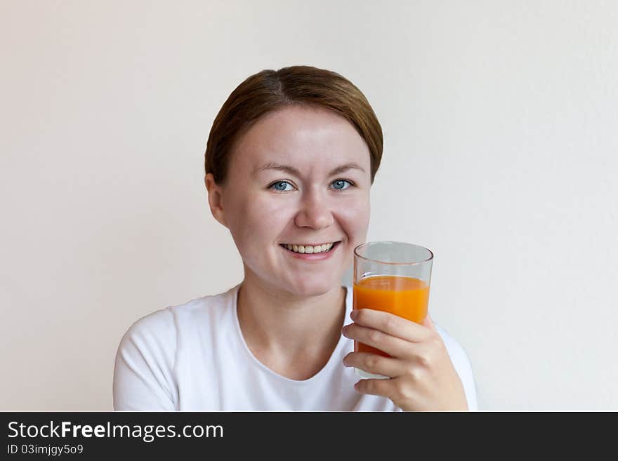 Woman holding a glass of orange juice and smiling