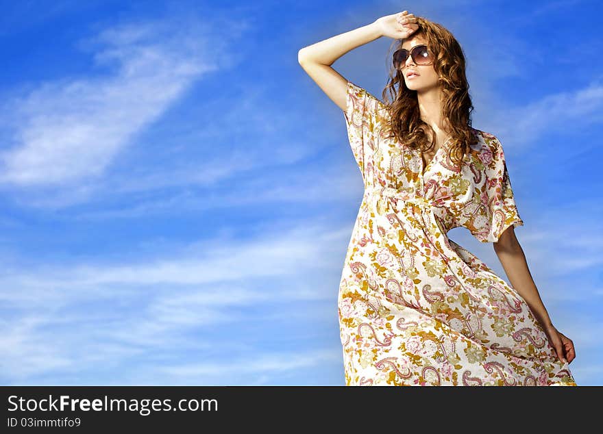 Portrait of beautiful brunette girl in sunglasses on background blue sky. Portrait of beautiful brunette girl in sunglasses on background blue sky