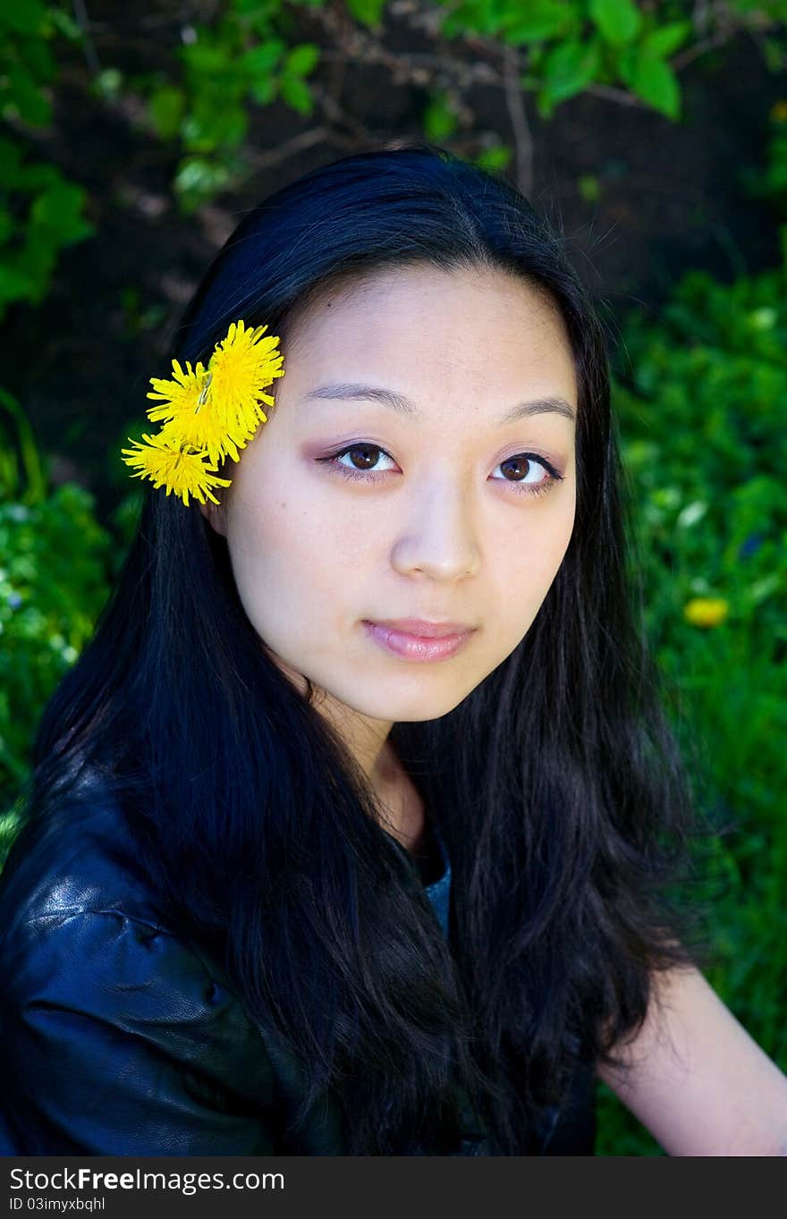 Beautiful young asian girl with dandelion flower in hair