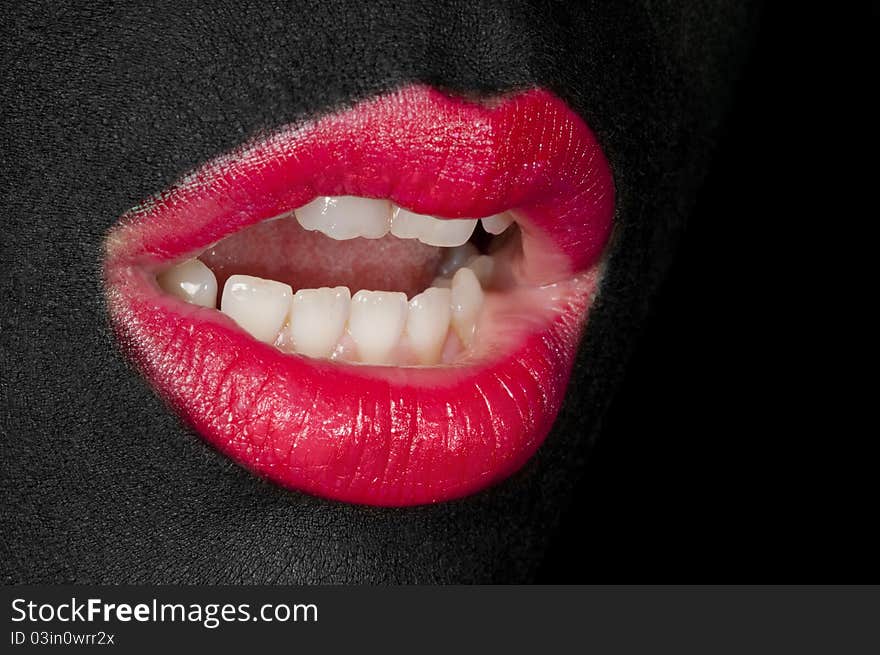 Photo of a young girl with a face painted totally black. Her lips are painted red. Her mouth is open and her teeth is visible. Photo of a young girl with a face painted totally black. Her lips are painted red. Her mouth is open and her teeth is visible.