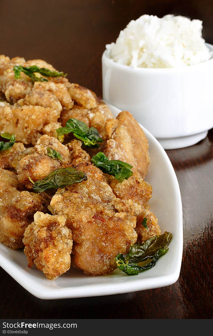 Thai deep fried chicken and basil served with a side of white rice. Thai deep fried chicken and basil served with a side of white rice