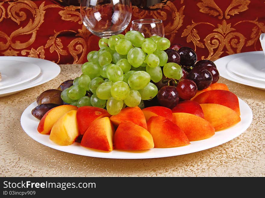 Grape and peach on white dish. Restaurant