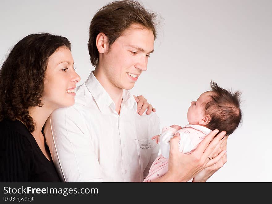 Happy young family with newborn on a white. Happy young family with newborn on a white