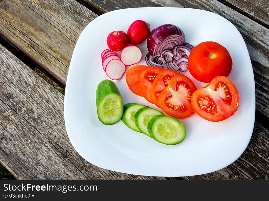 Fresh vegetable on plate on a wooden table. Fresh vegetable on plate on a wooden table