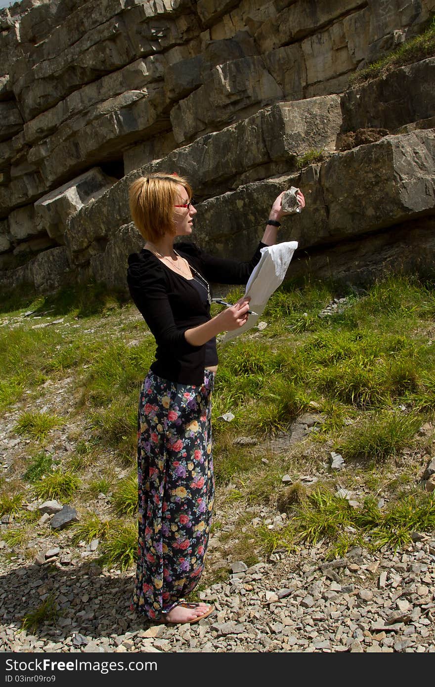 Woman inspecting rock.