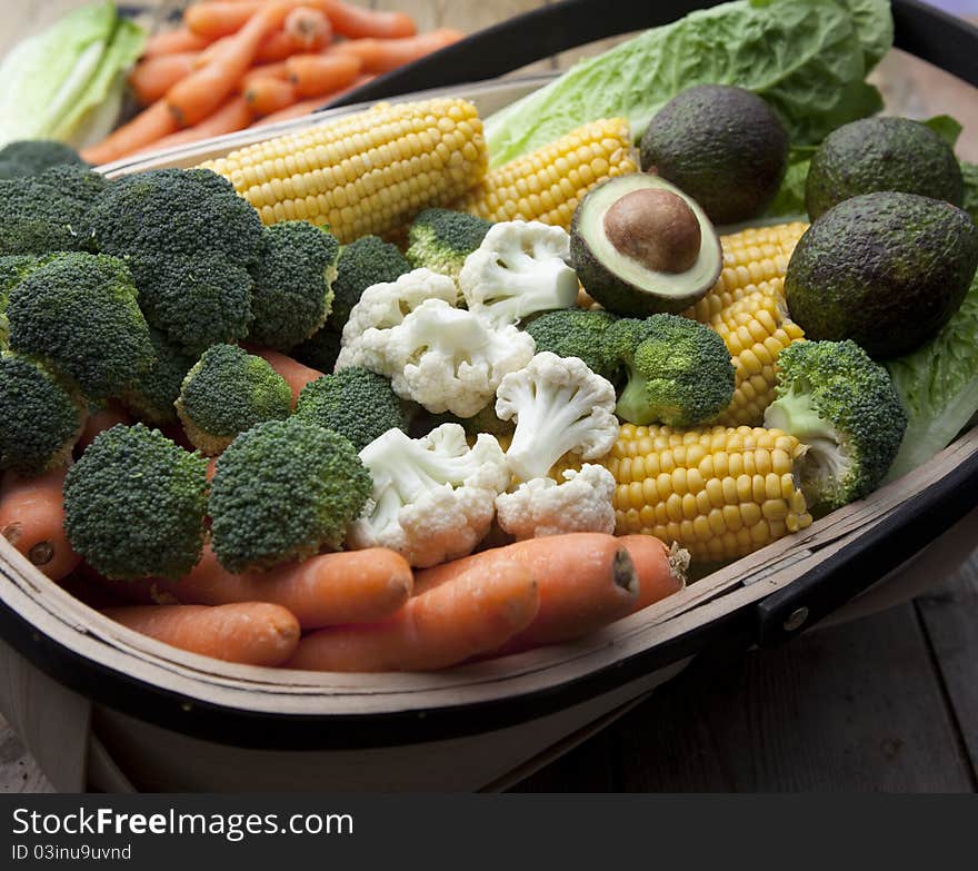 Various types of fruit and vegetables freshly harvested and laid in a garden trug. Various types of fruit and vegetables freshly harvested and laid in a garden trug