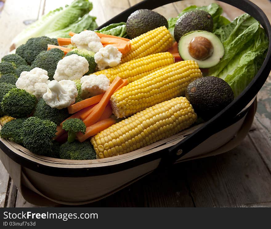 Various types of fruit and vegetables freshly harvested and laid in a garden trug. Various types of fruit and vegetables freshly harvested and laid in a garden trug