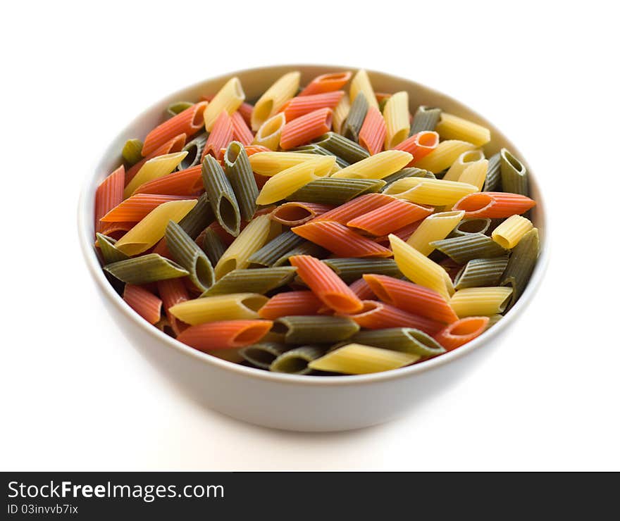 Multi coloured pasta penne in a white dish isolated on a white background. Multi coloured pasta penne in a white dish isolated on a white background