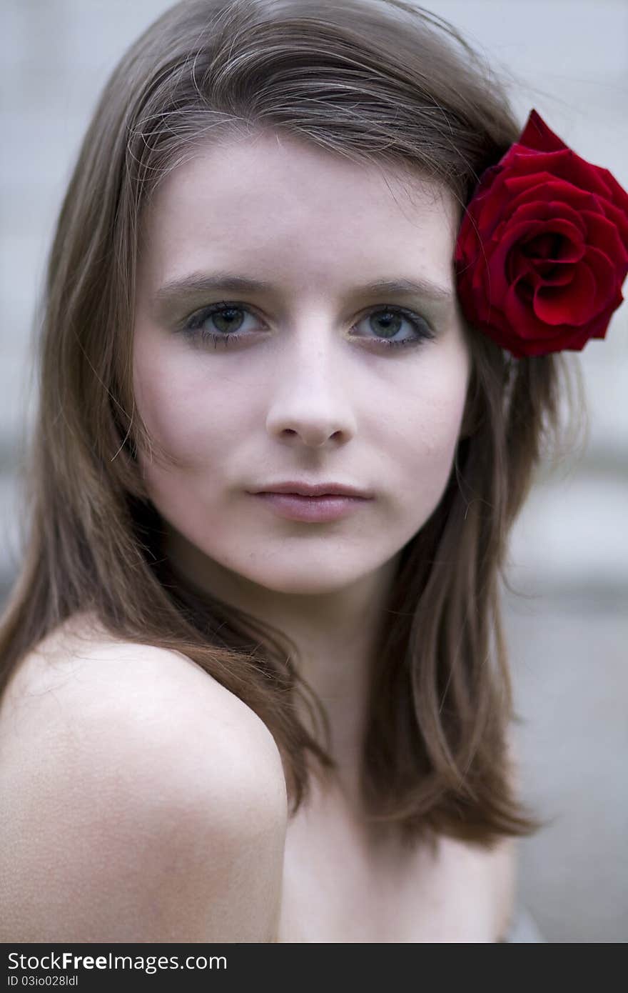 Portrait of a young woman with a rose in her hair