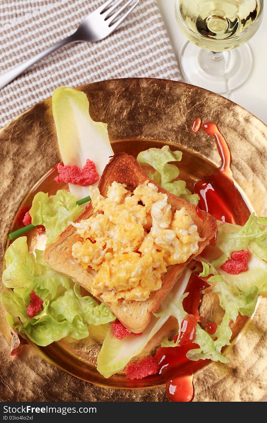 Scrambled eggs on toast and fresh salad