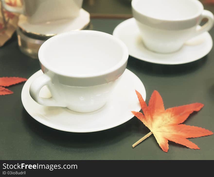 Tea cup and maple leaf on table