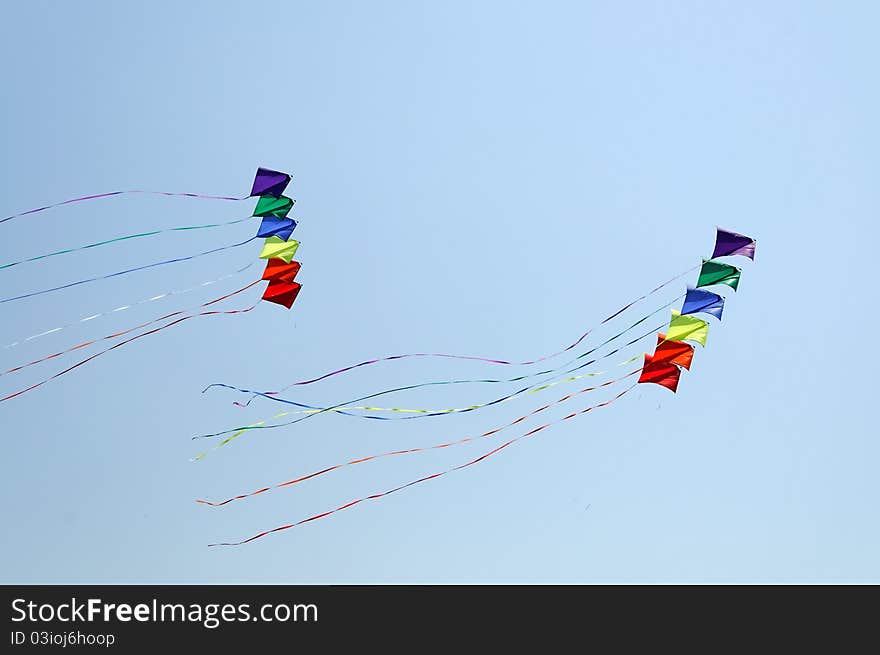 Colorful kite flying against blue sky. Summer Kite Festival. Colorful kite flying against blue sky. Summer Kite Festival