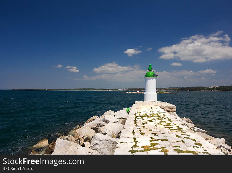 Small solar-powered lighthouse at the end of a jetty