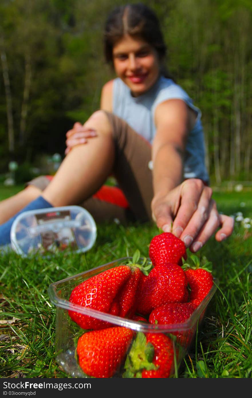 Young woman grabbing for fresh strawberry. Young woman grabbing for fresh strawberry