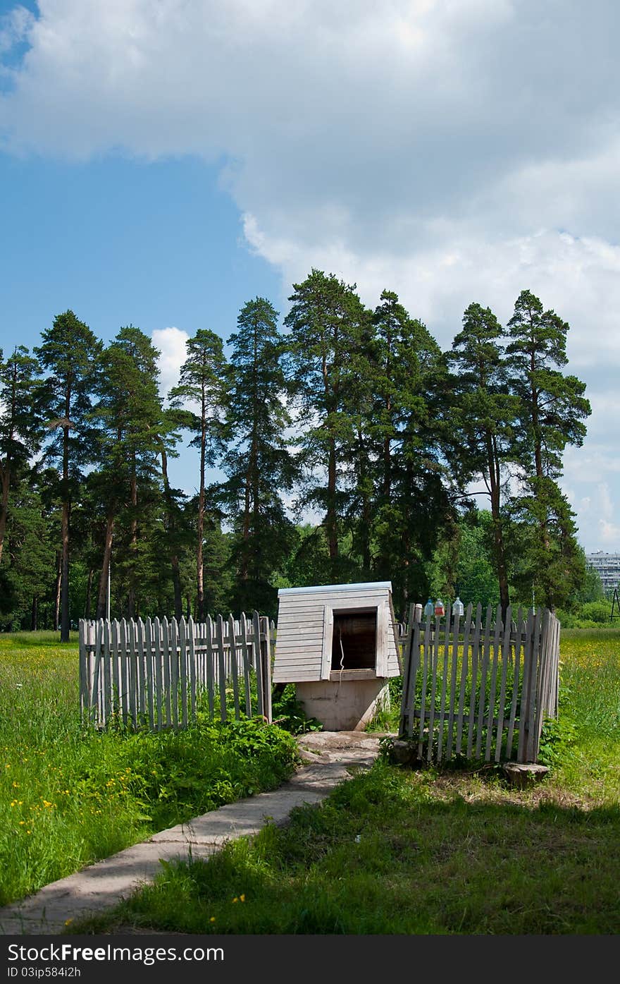 Wooden village well with a fence