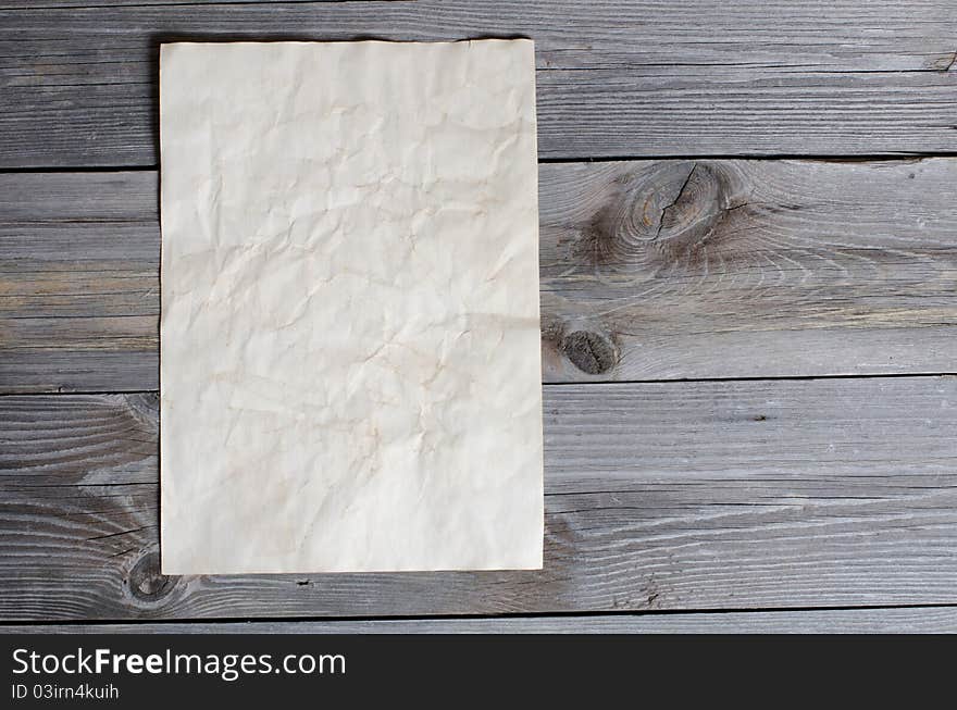 The old paper on a wooden surface. The old paper on a wooden surface