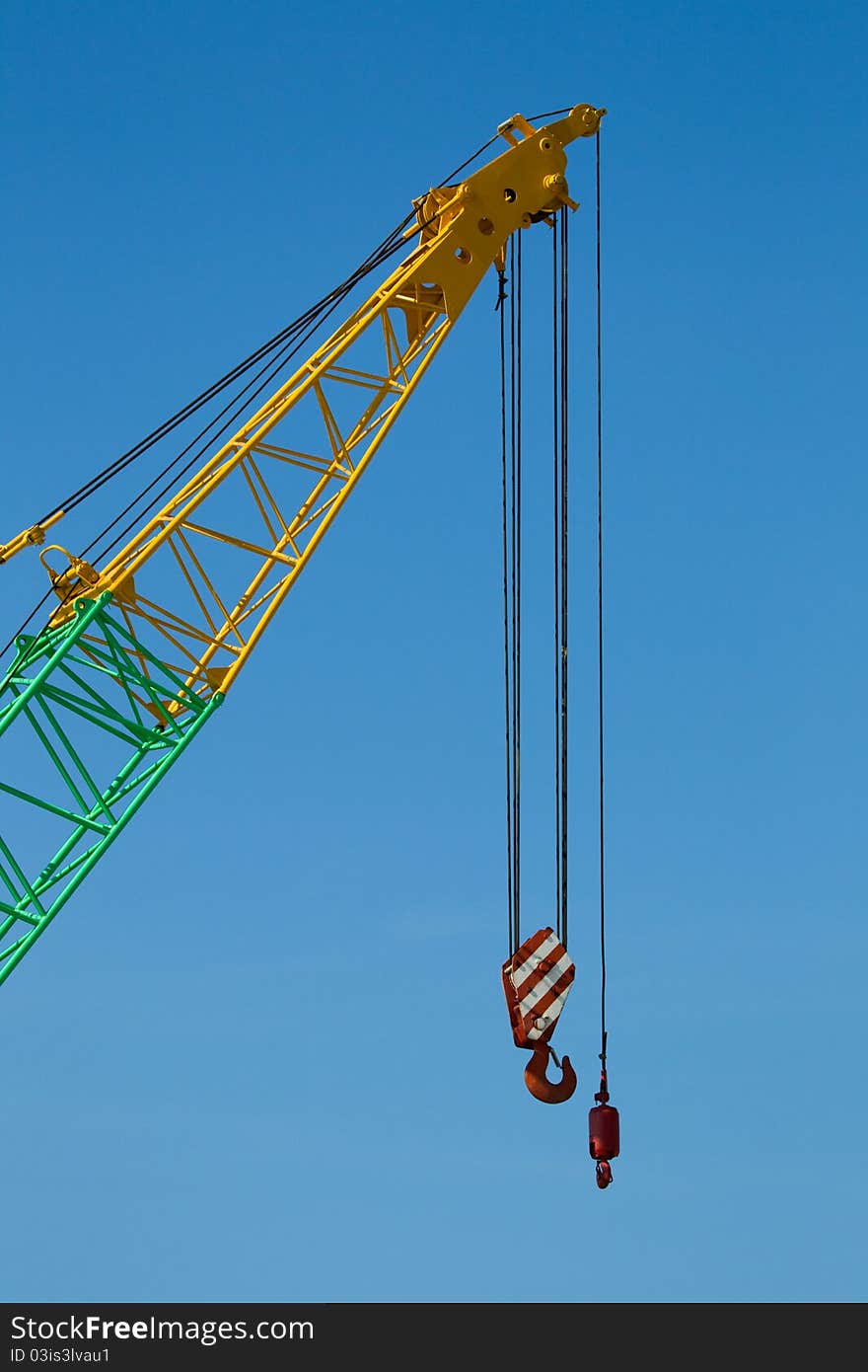 A Crane boom with main block and jib against a clear blue sky. A Crane boom with main block and jib against a clear blue sky