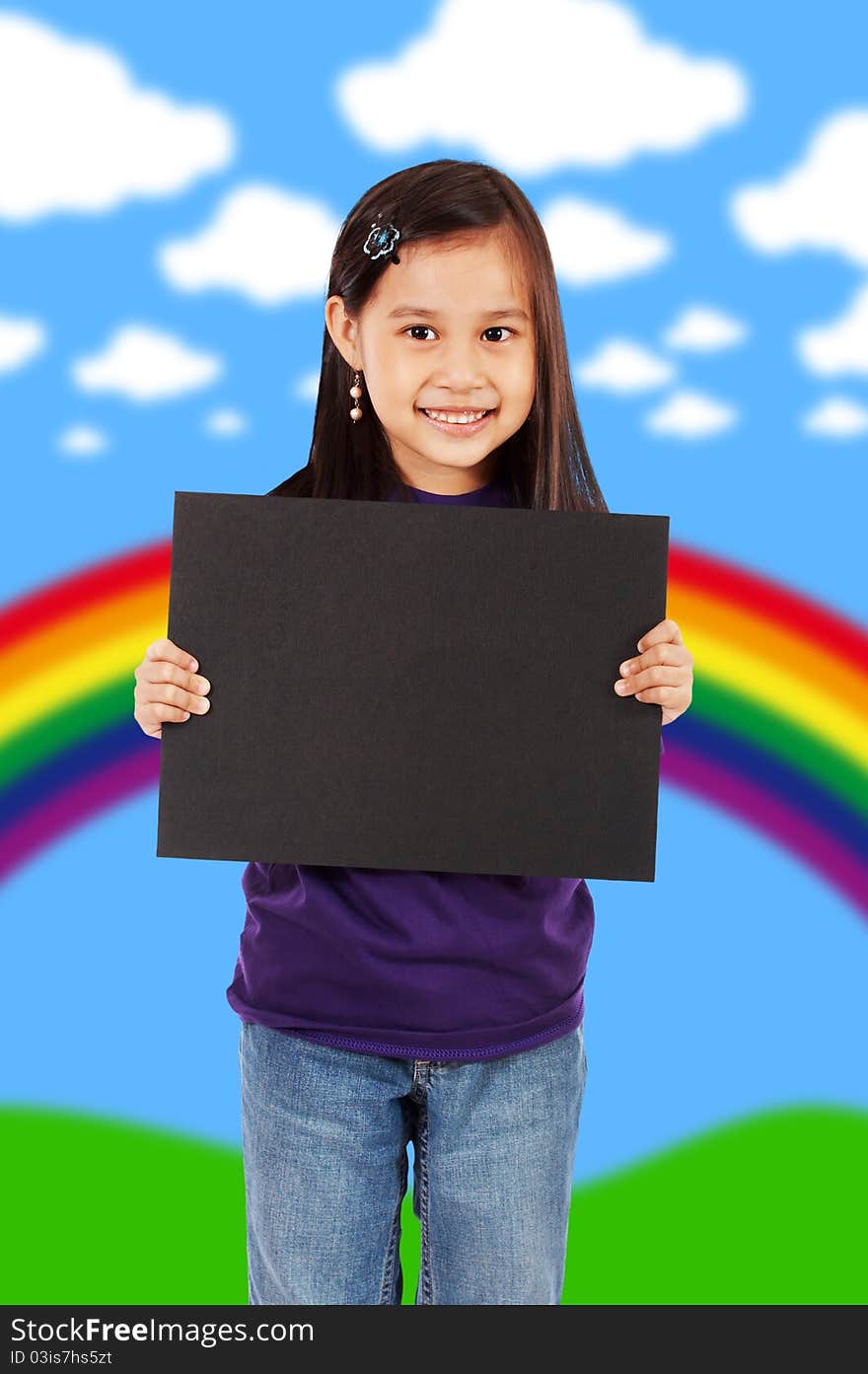 A Smiling Girl Holding A Blank Black Board With An Abstract Rainbow And Clouds Background