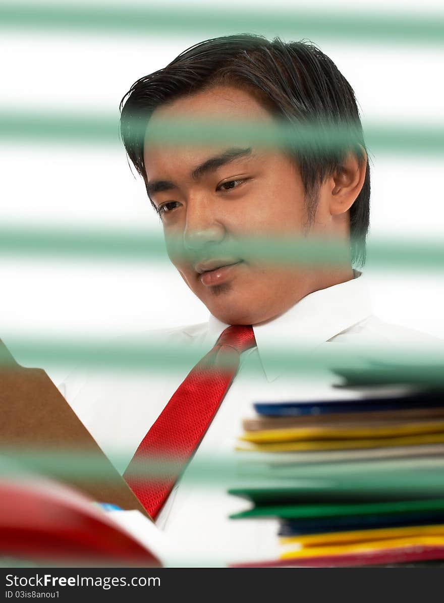 Man sitting at his office desk and reading a document in a folder. Man sitting at his office desk and reading a document in a folder